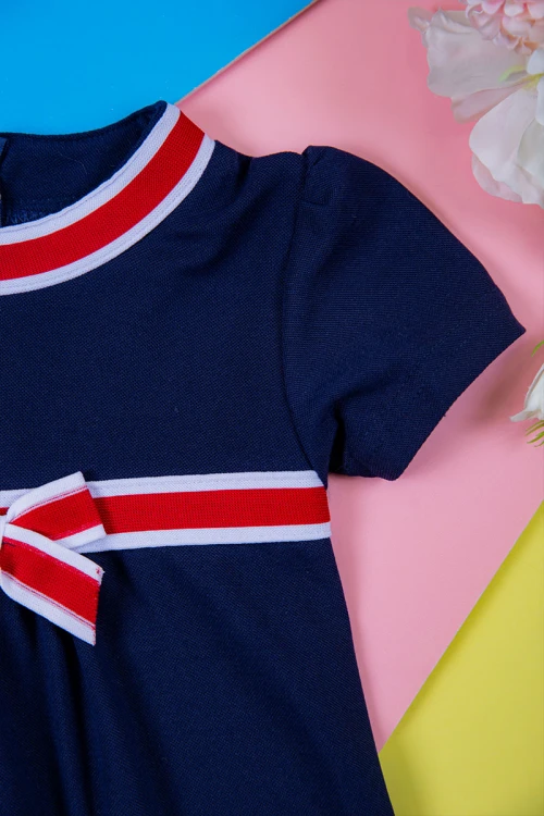 فستان بناتي متعدد الاوان بأكمام قصيرة و ياقة عالية مزينة باللون الأحمر و الكحلي و بفيونكة في الوسط بسحاب مخفي من الخلف