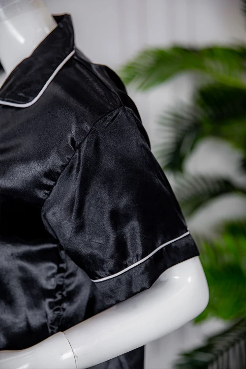 بيجاما نسائية ساتان قطعتين لون أسود بلوزة بياقة مطوية و جيب و أزرار من الأمام ذو أكمام قصيرة مع بنطلون طويل