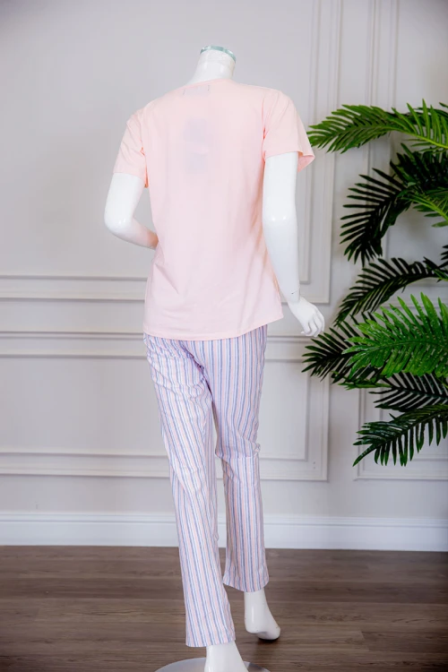 بيجاما نسائية قطعتين تيشيرت لون خربزي بياقة دائرية مزينة بكتابات و رسومات من الأمام مع بنطلون طويل مخطط برباط في الخصر