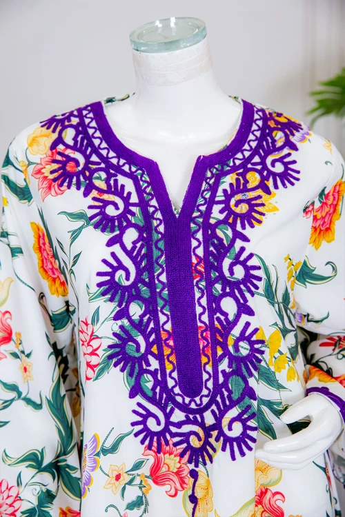 جلابية نسائية طويلة لون أبيض بتشجير ملون ياقة دائرية بكلفة مطرزة باللون الموف و أكمام طويلة