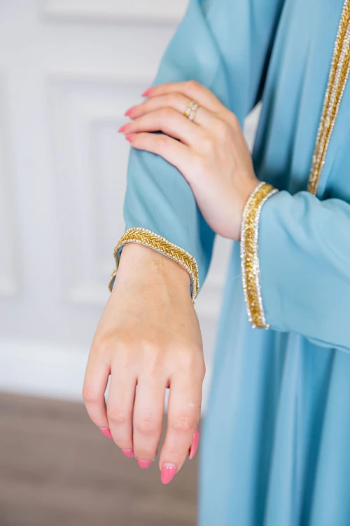 جلابية نسائية لون سماوي ياقة بقصة سبعة بتطريز ذهبي ذو أكمام طويلة