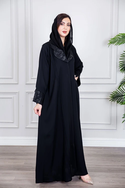عباية نسائية أنيقة لون أسود ياقة مطوية مزينة بنقوش في الياقة و أطراف الأكمام بأزرار من الأمام مع طرحة