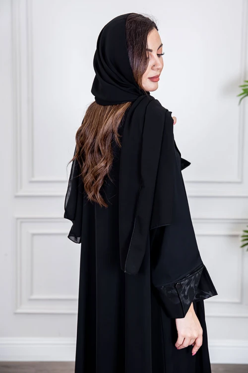 عباية نسائية أنيقة لون أسود ياقة مطوية مزينة بنقوش في الياقة و أطراف الأكمام بأزرار من الأمام مع طرحة