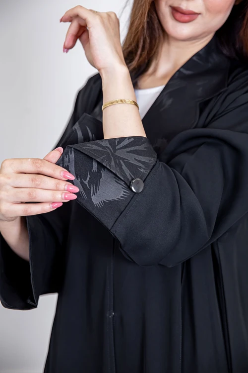 عباية نسائية أنيقة لون أسود ياقة مطوية مزينة بنقوش في الياقة و أطراف الأكمام بأزرار من الأمام مع طرحة