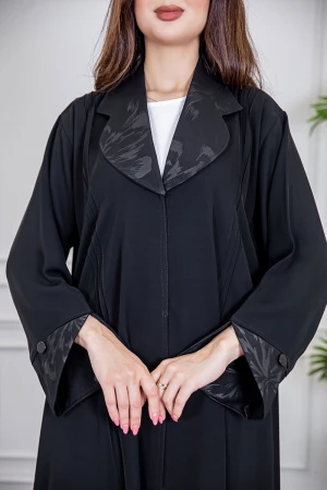 عباية نسائية أنيقة لون أسود ياقة مطوية مزينة بنقوش في الياقة و أطراف الأكمام بأزرار من الأمام مع طرحة