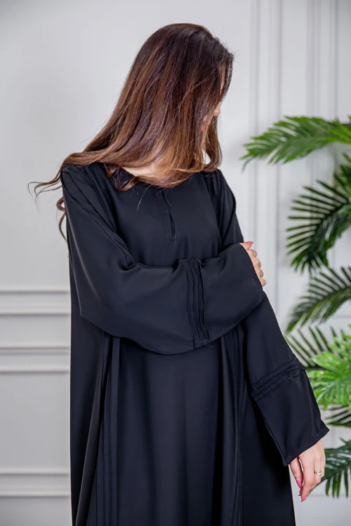 عباية نسائية أنيقة لون أسود ياقة دائرية بأزرار مزينة بطيات طويلة مغلقة من الأمام مع طرحة