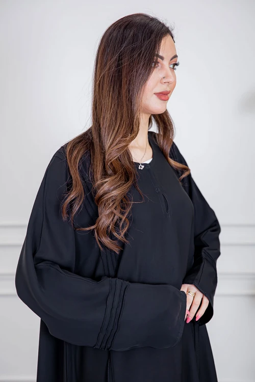 عباية نسائية أنيقة لون أسود ياقة دائرية بأزرار مزينة بطيات طويلة مغلقة من الأمام مع طرحة