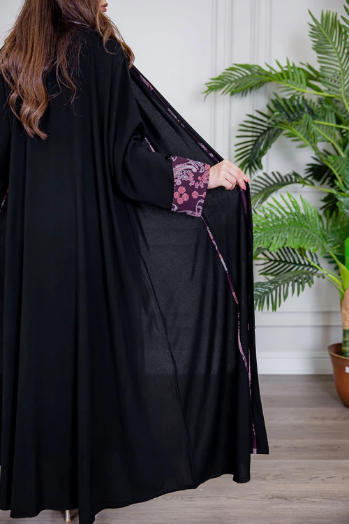 عباية نسائية أنيقة لون أسود ياقة قصة سبعة بأزرار من الأمام مزينة بطيات طويلة ملونة و من أطراف الأكمام مع طرحة