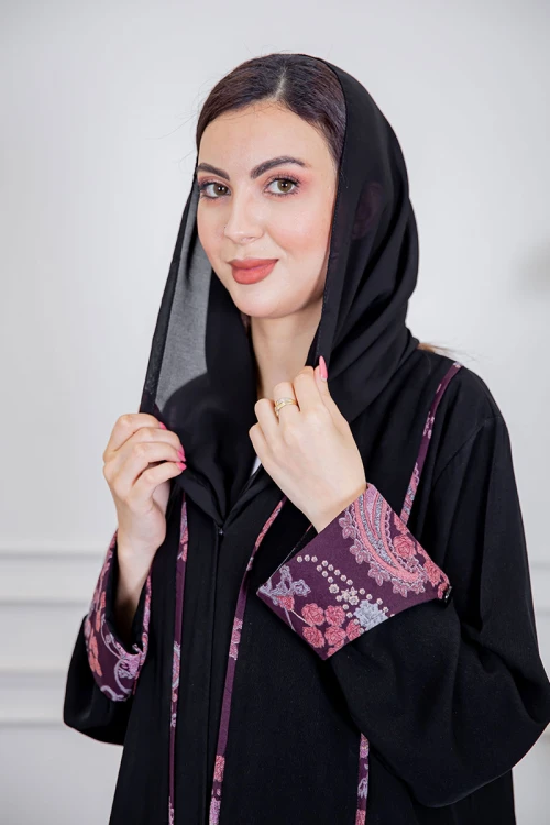 عباية نسائية أنيقة لون أسود ياقة قصة سبعة بأزرار من الأمام مزينة بطيات طويلة ملونة و من أطراف الأكمام مع طرحة