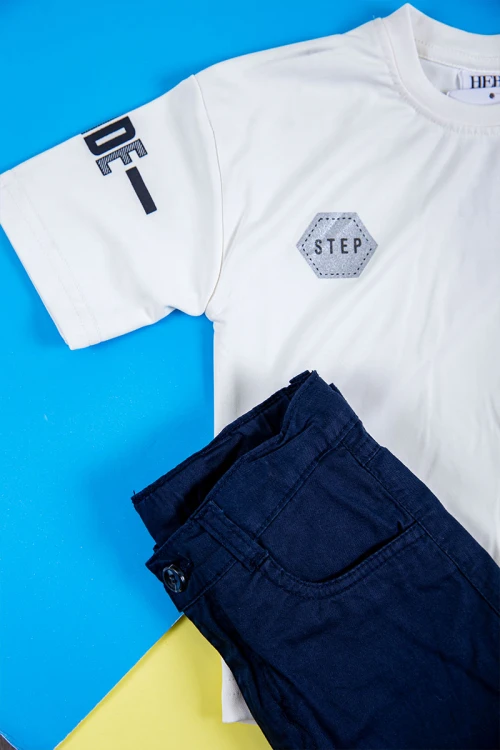 طقم ولادي قطعتين تيشيرت لون أبيض بكتابات و طبعات من الأمام و الخلف و بنطلون طويل لون كحلي بجيوب من الجانبين و الخلف