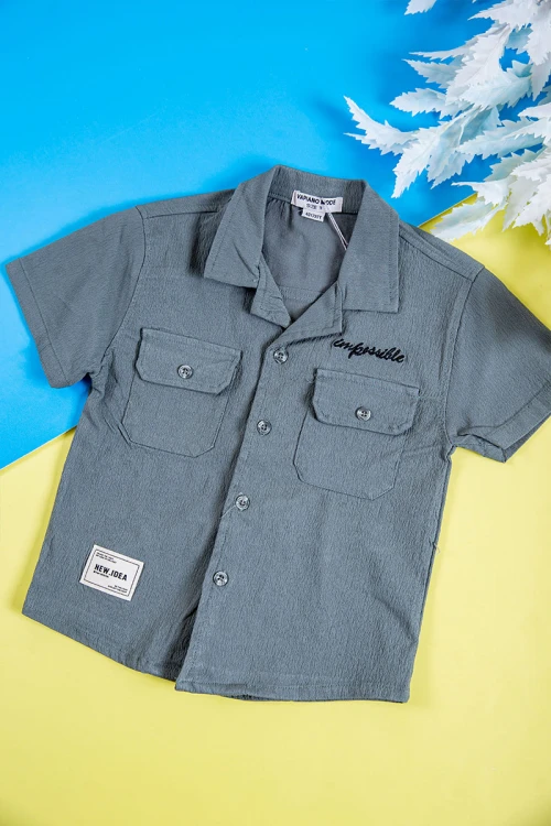 طقم ولادي قطعتين لون رصاصي قميص بكتابات و طبعات وجيوب وازرار من الأمام و شورت برباط في الخصر و جيوب من الجانبين و الخلف