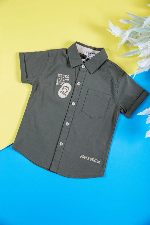 طقم ولادي قطعتين قميص لون زيتي بكتابات و طبعات و أزرار و جيب من الأمام و بنطلون طويل لون بيج فاتح برباط في الخصر و جيوب من الجانبين و الخلف