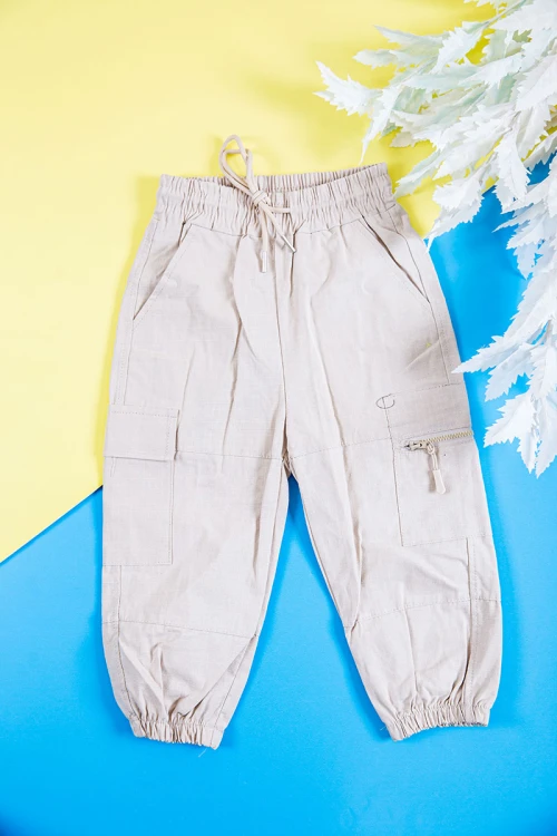 طقم ولادي قطعتين قميص لون زيتي بكتابات و طبعات و أزرار و جيب من الأمام و بنطلون طويل لون بيج فاتح برباط في الخصر و جيوب من الجانبين و الخلف