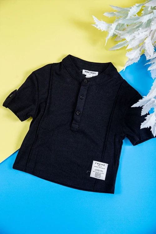 طقم ولادي قطعتين بلوزة لون أسود بطبعات و أزرار من الأمام و الأكمام و بنطلون طويل لون بيج فاتح برباط في الخصر و جيوب و سحاب من الجانبين