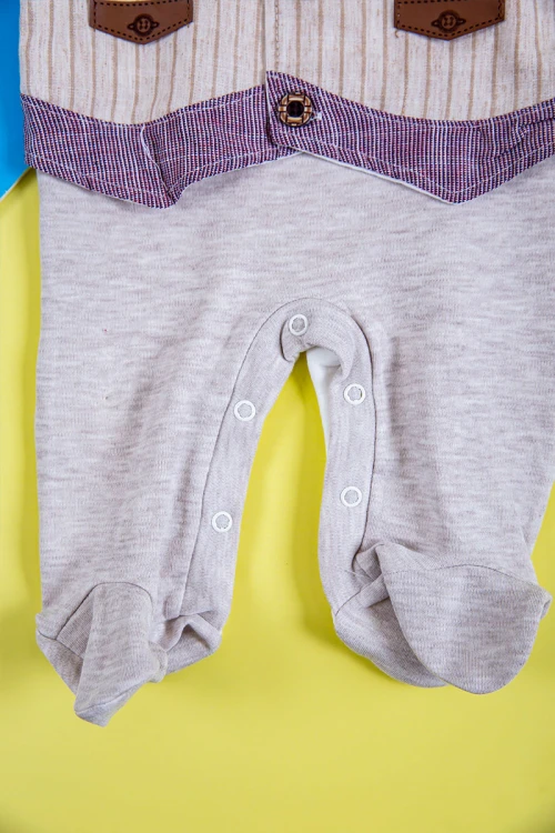 بربتوز أطفال لون بيج  مزين من الأمام ذو أكمام طويلة و أزرار من الخلف و الأسفل مع قبعة