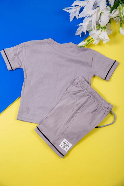 طقم ولادي قطعتين لون رمادي تيشيرت بكتابات و طبعات من الأمام و شورت برباط في الخصر و جيوب من الجانبين