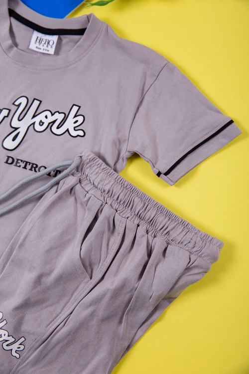 طقم ولادي قطعتين لون رمادي تيشيرت بكتابات و طبعات من الأمام و شورت برباط في الخصر و جيوب من الجانبين