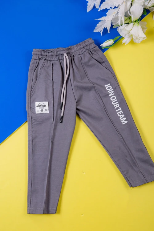 طقم ولادي قطعتين لون رصاصي تيشيرت بكتابات و طبعات من الأمام و الخلف و بنطلون طويل برباط في الخصر و جيوب من الجانبين