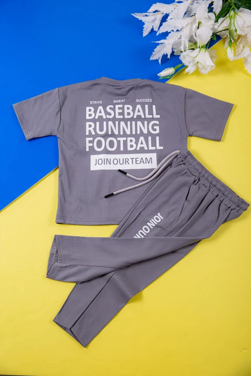 طقم ولادي قطعتين لون رصاصي تيشيرت بكتابات و طبعات من الأمام و الخلف و بنطلون طويل برباط في الخصر و جيوب من الجانبين