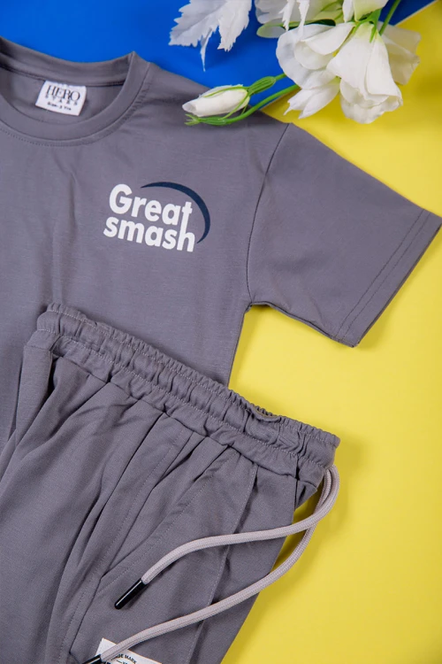 طقم ولادي قطعتين لون رصاصي تيشيرت بكتابات و طبعات من الأمام و الخلف و بنطلون طويل برباط في الخصر و جيوب من الجانبين