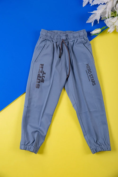 طقم ولادي قطعتين لون أزرق تيشيرت بكتابات و طبعات من الأمام و بنطلون طويل برباط في الخصر و جيوب من الجانبين وزم في الأسفل