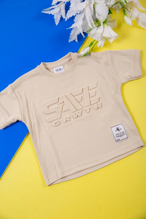 طقم ولادي قطعتين لون بيج تيشيرت بكتابات و طبعات من الأمام و شورت برباط في الخصر و جيوب من الجانبين