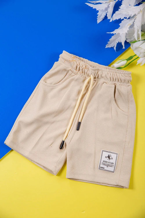 طقم ولادي قطعتين لون بيج تيشيرت بكتابات و طبعات من الأمام و شورت برباط في الخصر و جيوب من الجانبين