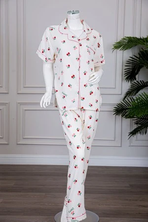 بيجاما نسائية قطعتين لون بيج مزينة برسومات بلوزة بياقة مطوية و بجيب و أزرار من الأمام مع بنطلون طويل