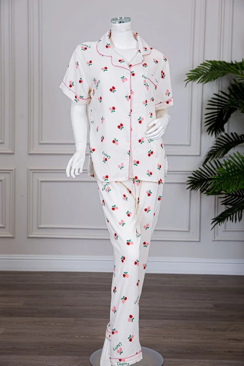 بيجاما نسائية قطعتين لون بيج مزينة برسومات بلوزة بياقة مطوية و بجيب و أزرار من الأمام مع بنطلون طويل