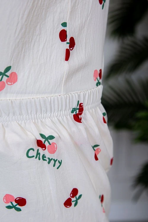 بيجاما نسائية قطعتين لون بيج مزينة برسومات بلوزة بياقة مطوية و بجيب و أزرار من الأمام مع بنطلون طويل