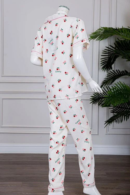 بيجاما نسائية قطعتين لون بيج مزينة برسومات بلوزة بياقة مطوية و بجيب و أزرار من الأمام مع بنطلون طويل