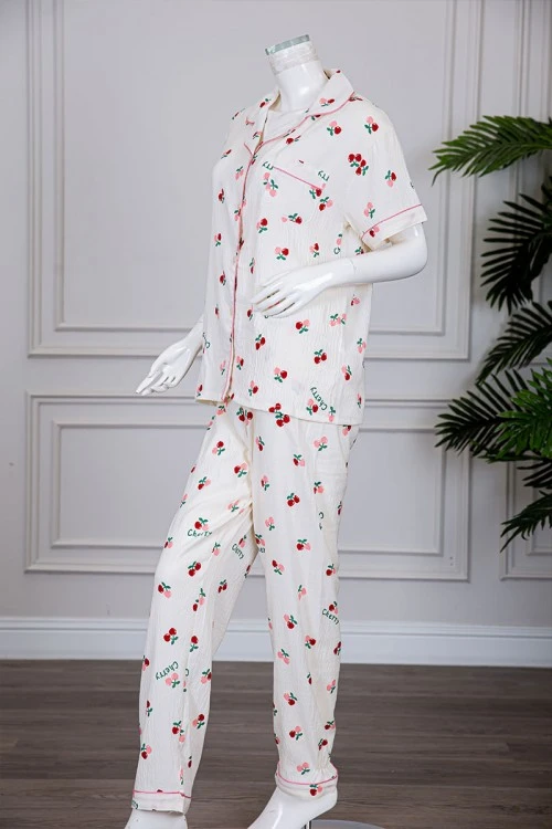 بيجاما نسائية قطعتين لون بيج مزينة برسومات بلوزة بياقة مطوية و بجيب و أزرار من الأمام مع بنطلون طويل