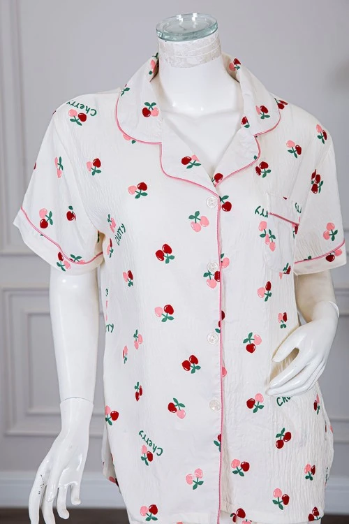 بيجاما نسائية قطعتين لون بيج مزينة برسومات بلوزة بياقة مطوية و بجيب و أزرار من الأمام مع بنطلون طويل