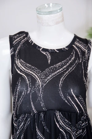 قميص نسائي قصير لون أسود مزين برسومات باللون البيج ياقة دائرية و بدون أكمام