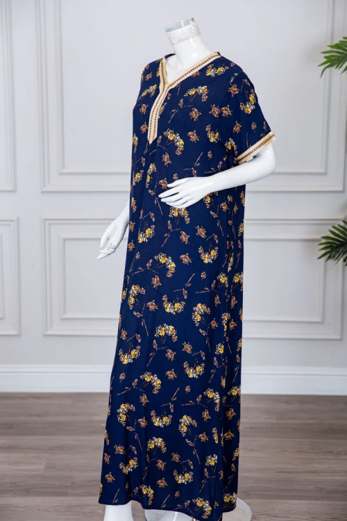 قميص نسائي طويل لون كحلي مزين برسومات ملونة و بكلفة مطرزة باللون الذهبي في الياقة و الأكمام