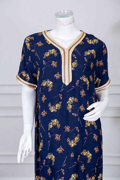 قميص نسائي طويل لون كحلي مزين برسومات ملونة و بكلفة مطرزة باللون الذهبي في الياقة و الأكمام