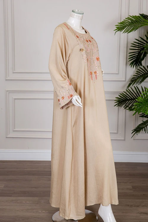جلابية نسائية لون بيج ياقة مربعة و أكمام طويلة مزينة بتطريز في الصدر و الأكمام
