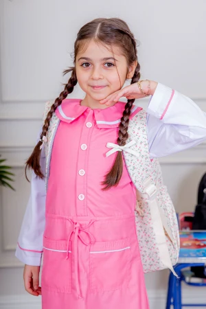 مريول بناتي مدرسي لون وردي مع قميص أبيض متصل بأزرار و جيوب من الأمام و رباط في الخصر 