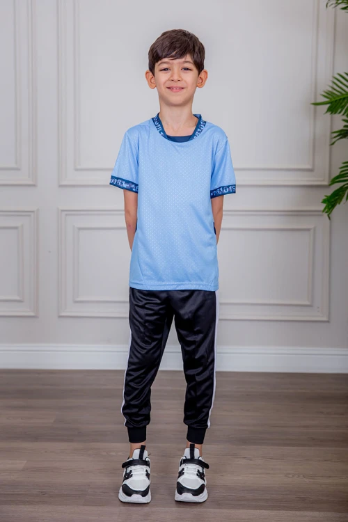 طقم ولادي رياضي قطعتين تيشيرت لون سماوي  مقلم باللون الذهبي و بنطلون طويل لون أسود مخطط باللون الأحمر من الجانبين و بزم من الأسفل