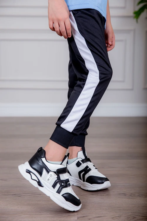 طقم ولادي رياضي قطعتين تيشيرت لون سماوي  مقلم باللون الذهبي و بنطلون طويل لون أسود مخطط باللون الأحمر من الجانبين و بزم من الأسفل