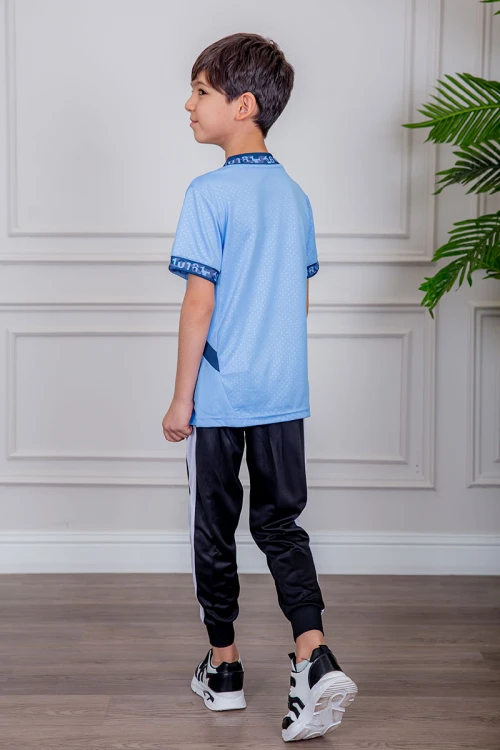 طقم ولادي رياضي قطعتين تيشيرت لون سماوي  مقلم باللون الذهبي و بنطلون طويل لون أسود مخطط باللون الأحمر من الجانبين و بزم من الأسفل