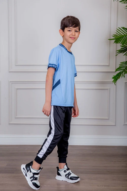 طقم ولادي رياضي قطعتين تيشيرت لون سماوي  مقلم باللون الذهبي و بنطلون طويل لون أسود مخطط باللون الأحمر من الجانبين و بزم من الأسفل