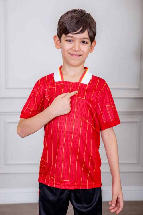 طقم ولادي رياضي قطعتين تيشيرت لون أحمر مقلم باللون الذهبي و بنطلون طويل لون أسود مخطط باللون الأحمر من الجانبين و بزم من الأسفل