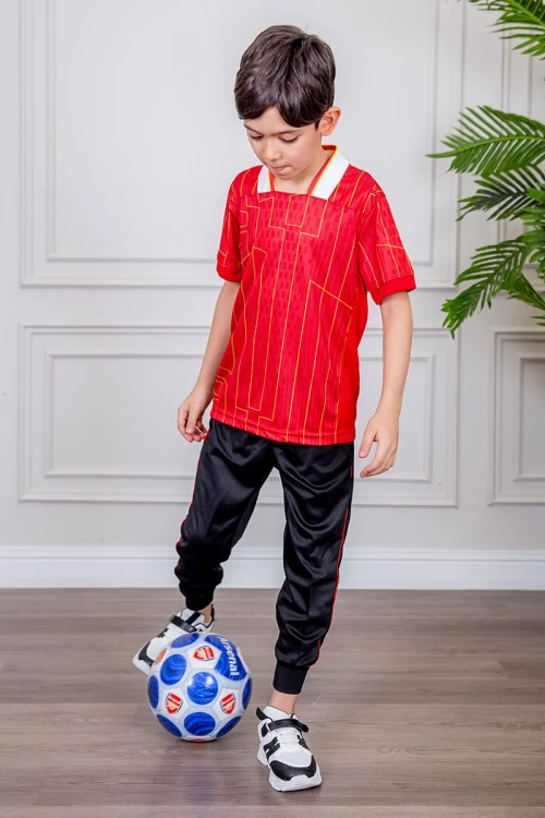 طقم ولادي رياضي قطعتين تيشيرت لون أحمر مقلم باللون الذهبي و بنطلون طويل لون أسود مخطط باللون الأحمر من الجانبين و بزم من الأسفل