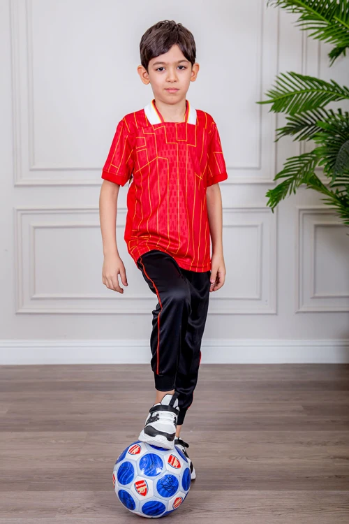 طقم ولادي رياضي قطعتين تيشيرت لون أحمر مقلم باللون الذهبي و بنطلون طويل لون أسود مخطط باللون الأحمر من الجانبين و بزم من الأسفل