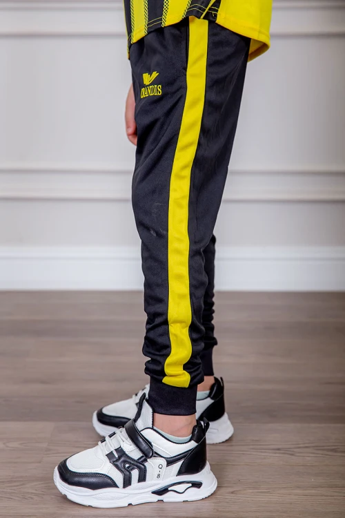 طقم ولادي رياضي قطعتين تيشيرت لون أصفر مقلم باللون الأسود و بنطلون طويل لون أسود مخطط باللون الأصفر من الجانبين و بزم من الأسفل