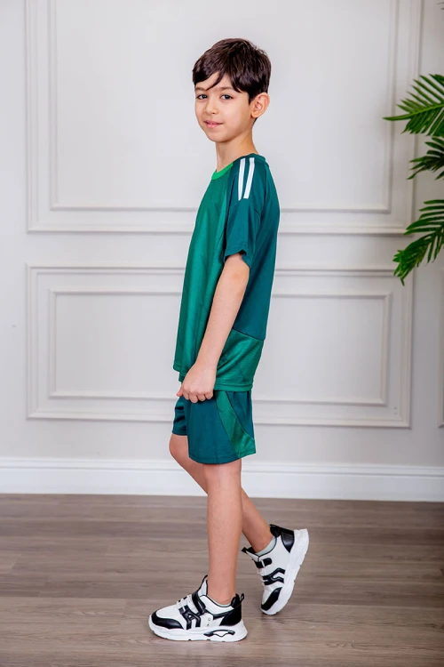 طقم ولادي رياضي قطعتين تيشيرت لون أخضر بياقة دائرية و أكتاف مخططة باللون الأبيض و شورت لون أخضر