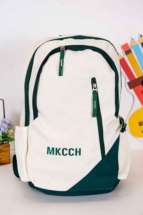 شنطة ظهر مدرسية لون بيج فاتح بحواف أخضر غامق و بجيوب متعددة