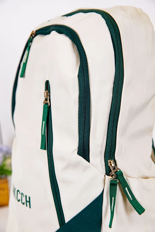 شنطة ظهر مدرسية لون بيج فاتح بحواف أخضر غامق و بجيوب متعددة