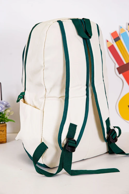 شنطة ظهر مدرسية لون بيج فاتح بحواف أخضر غامق و بجيوب متعددة